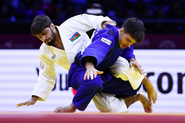 Azerbaijan's Rashid Mammadaliyev (white) competes against Canada's Justin Lemire in the men's under 73 kg round of 32 at the World Judo Championships in Baku on October 6, 2026. (Photo by Anne-Christine POUJOULAT / AFP)