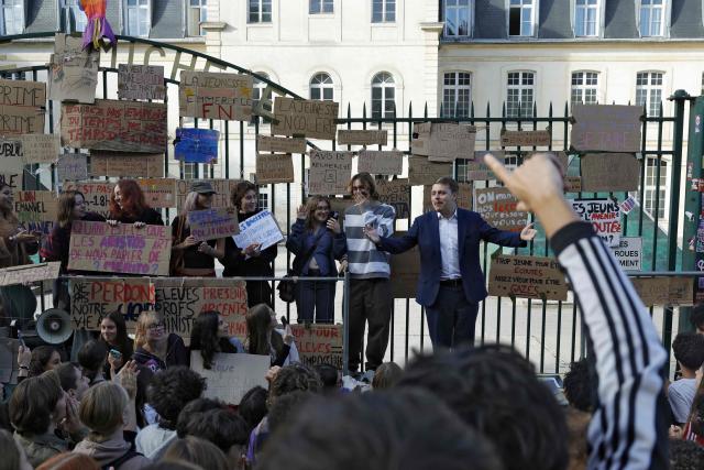 Left-wing La France Insoumise (LFI) MP Louis Boyard (background, R) delivers a speech in front of the Michelet high school during a demonstration of high-school students as part of a nationwide protest movement over learning conditions in Vanves, outside Paris, on October 6, 2026. Since late September, pupils have barred the entrances to hundreds of schools, complaining of teacher absences, overloaded timetables, dilapidated classrooms and buildings ill-adapted to rising temperatures, among other grievances. (Photo by GEOFFROY VAN DER HASSELT / AFP)
