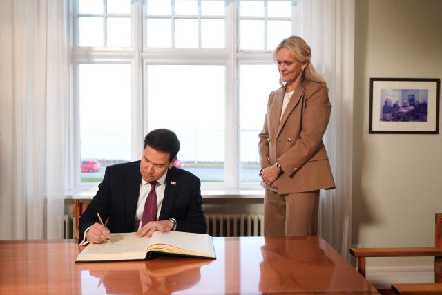 US Secretary of State Marco Rubio signs a guests book as Iceland's Foreign Minister Thorgerdur Katrin Gunnarsdottir looks on during a visit at Hofdi House as part of Rubio's European tour, in Reykjavik on October 6, 2026. US Secretary of State Marco Rubio starts in Iceland a three-nation European tour to push for greater US influence in the Arctic after Washington sealed a pact on Greenland. After Iceland, Rubio continues to Athens to participate in a "strategic dialogue" with NATO member Greece on regional and energy security before heading to Portugal. (Photo by Mark Schiefelbein / POOL / AFP)