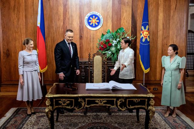 Philippine President Ferdinand Marcos Jr (2R) gestures as Poland's President Karol Nawrocki (2L) arrives to sign a guest book at Malacanang Palace in Manila on October 6, 2026. (Photo by Ezra Acayan / POOL / AFP)