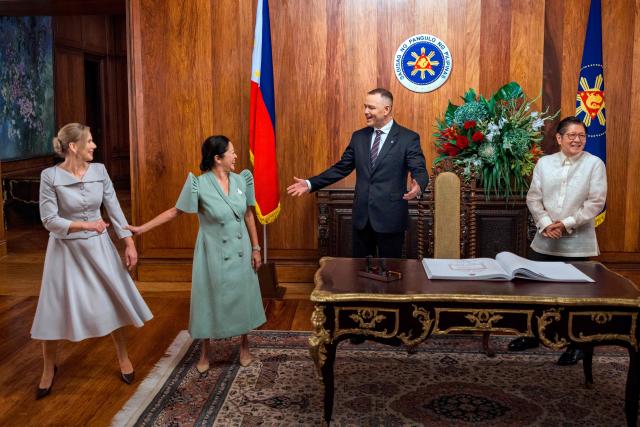 Philippines President Ferdinand Marcos Jr (R) and Poland's President Karol Nawrocki (2R) react after signing a guest book at Malacanang Palace in Manila on October 6, 2026. (Photo by Ezra Acayan / POOL / AFP)