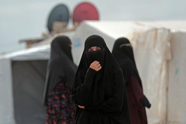 Women stand outside their tents at the Roj detention camp built for relatives of suspected jihadists, in the northeast of Syria on October 5, 2026. (Photo by Delil SOULEIMAN / AFP)