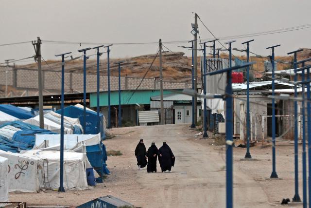 Women walk through the Roj detention camp built for relatives of suspected jihadists, in the northeast of Syria on October 5, 2026. (Photo by Delil SOULEIMAN / AFP)