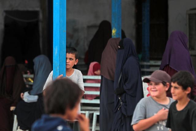 Women and children gather outside a shop at the Roj detention camp built for relatives of suspected jihadists, in the northeast of Syria on October 5, 2026. (Photo by Delil SOULEIMAN / AFP)