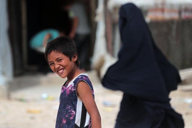 A boy reacts while walking through the Roj detention camp built for relatives of suspected jihadists, in the northeast of Syria on October 5, 2026. (Photo by Delil SOULEIMAN / AFP)