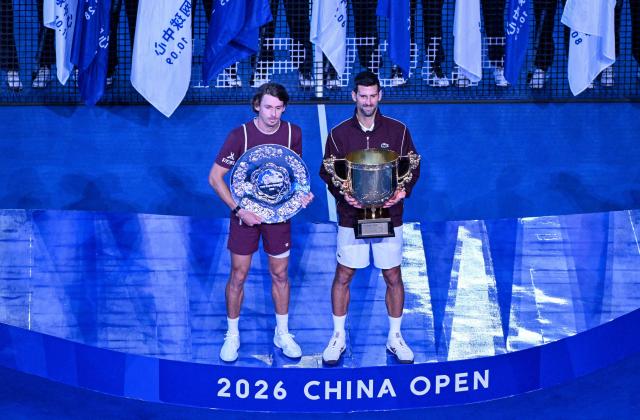 Winner Serbia's Novak Djokovic (R) and runner-up Australia's Alex de Minaur (L) pose for photographs at the China Open tennis tournament in Beijing on October 6, 2026. (Photo by Adek BERRY / AFP)