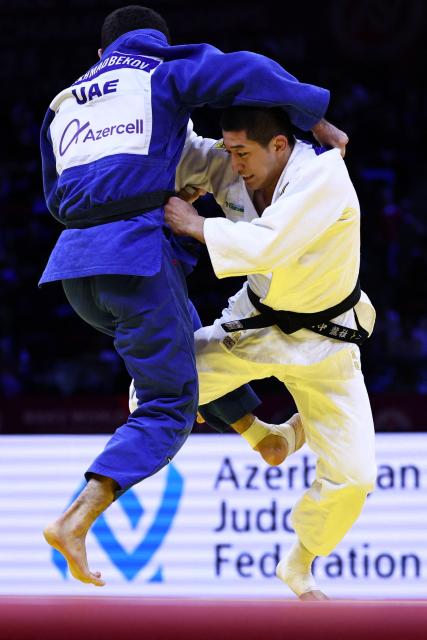Japan's Ryuga Tanaka (white) competes against United Arab Emirates' Makhmadbek Makhmadbekov in the men's under 73 kg category gold medal bout at the World Judo Championships in Baku on October 6, 2026. (Photo by Anne-Christine POUJOULAT / AFP)