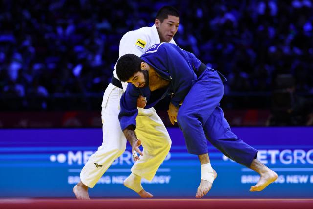 Japan's Ryuga Tanaka (white) competes against United Arab Emirates' Makhmadbek Makhmadbekov in the men's under 73 kg category gold medal bout at the World Judo Championships in Baku on October 6, 2026. (Photo by Anne-Christine POUJOULAT / AFP)