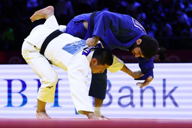 Japan's Ryuga Tanaka (white) competes against United Arab Emirates' Makhmadbek Makhmadbekov in the men's under 73 kg category gold medal bout at the World Judo Championships in Baku on October 6, 2026. (Photo by Anne-Christine POUJOULAT / AFP)