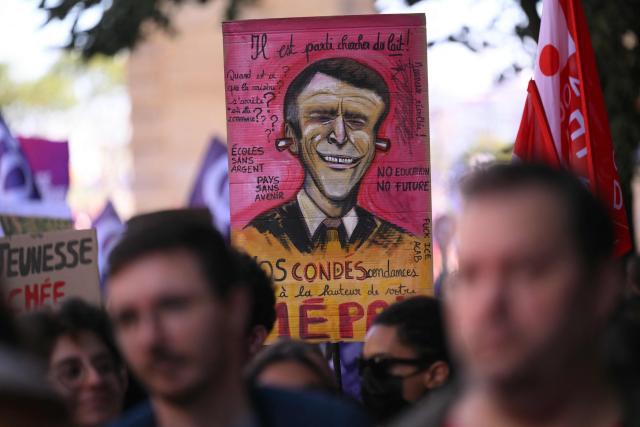 Protestors hold a placard depicting a caricature of France's President Emmanuel Macron during a demonstration of high-school students as part of a nationwide protest movement over learning conditions in the south-western city of Bordeaux on October 6, 2026. Since late September, pupils have barred the entrances to hundreds of schools, complaining of teacher absences, overloaded timetables, dilapidated classrooms and buildings ill-adapted to rising temperatures, among other grievances. (Photo by Christophe ARCHAMBAULT / AFP)
