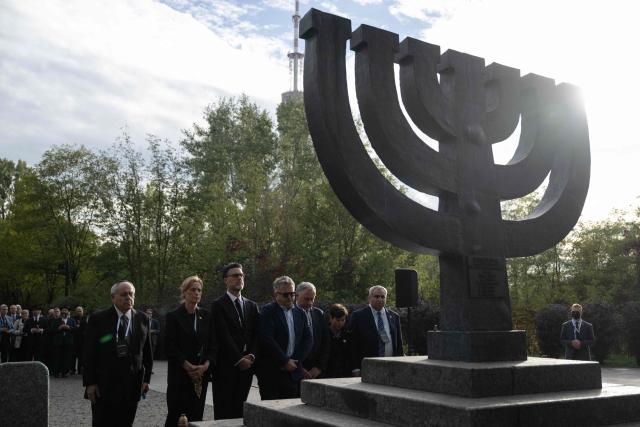 Federal Minister of Education, Family, Senior Citizens, Women and Youth of Germany Karin Prien (2L) and Member of the Knesset and minister in the Finance Ministry of Israel Ze’ev Elkin (R) take part in a memorial ceremony at the Babyn Yar National Historical and Memorial Reserve to honor the victims of the mass execution of civilians by the Nazis during World War II, in Kyiv on October 6, 2026, amid the Russian invasion of Ukraine. (Photo by Genya SAVILOV / AFP)