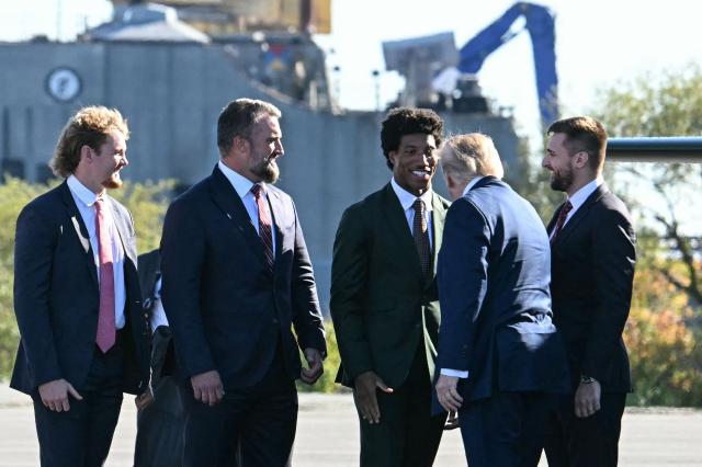 US President Donald Trump speaks with Baltimore Ravens football player Marlon Humphrey upon arrival in Sparrows Point, Maryland, ahead of an event at Anduril Industries, on October 6, 2026. Anduril Industries is making an announcement about its future plans at the former Bethlehem Steel location. (Photo by Jim WATSON / AFP)