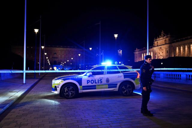 A policeman stands next to a police cordon and vehicle after police shot a man acting out armed with a knife, near the Royal Palace in central Stockholm, Sweden, on October 6, 2026. Swedish police said on October 6 they shot an armed man outside the Royal Palace in central Stockholm after receiving reports of a disruptive individual carrying a weapon. Police said officers responding to the incident opened fire on the man. "The man was hit and taken to hospital," a Stockholm police spokeswoman told AFP. She said his injuries were considered serious but not life-threatening. (Photo by Jessica GOW / TT News Agency / AFP) / Sweden OUT