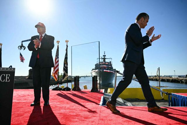 (L/R) US President Donald Trump arrives to speak as Secretary of Defense Pete Hegseth departs after delivering remarks at Anduril Industries in Sparrows Point, Maryland, on October 6, 2026. (Photo by Jim WATSON / AFP)