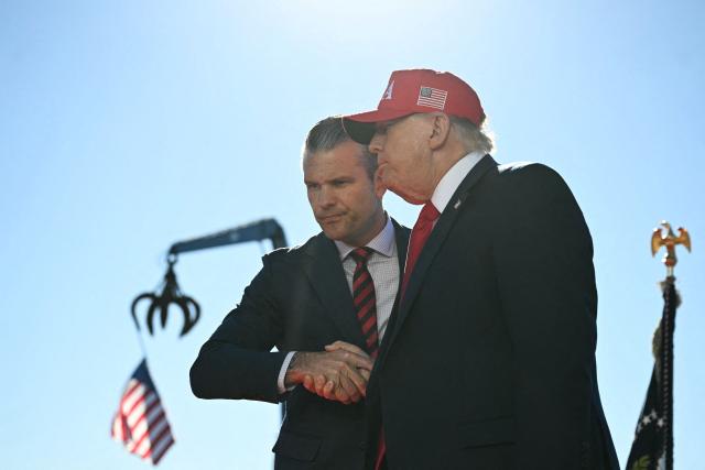 US President Donald Trump (R) shakes hands with Secretary of Defense Pete Hegseth as he arrives to speak at Anduril Industries in Sparrows Point, Maryland, on October 6, 2026. (Photo by Jim WATSON / AFP)