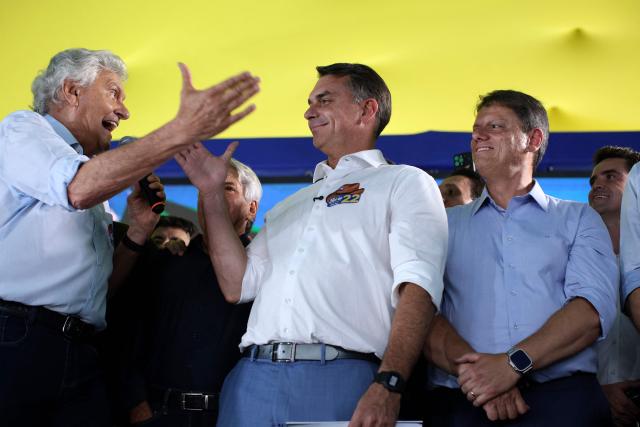 Brazil's right-wing senator and Liberal Party (PL) presidential candidate Flavio Bolsonaro (C) is greeted by former presidential candidate Ronaldo Caiado (L) as Sao Paulo Governor Tarcisio de Freitas looks on during a rally in Goiania, Goias state, Brazil, on October 6, 2026. Right-wing Flavio Bolsonaro heads into Brazil's October 25 presidential runoff in a position of strength and with the backing of US President Donald Trump, while President Luiz Inacio Lula da Silva faces an uphill battle to stage a comeback. (Photo by Sergio Lima / AFP)