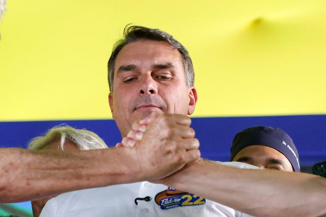 Brazil's right-wing senator and Liberal Party (PL) presidential candidate Flavio Bolsonaro looks on as supporters shake hands during a rally in Goiania, Goias state, Brazil, on October 6, 2026. Right-wing Flavio Bolsonaro heads into Brazil's October 25 presidential runoff in a position of strength and with the backing of US President Donald Trump, while President Luiz Inacio Lula da Silva faces an uphill battle to stage a comeback. (Photo by Sergio Lima / AFP)