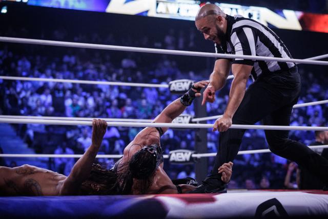 Wrestlers Bandido (C) and Kofi (L) lie on the floor while a referee points during the AEW Grand Slam event at the Adidas Arena in Paris on October 6, 2026. (Photo by Simon WOHLFAHRT / AFP)