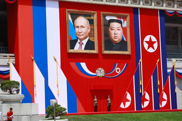 (FILES) In this pool photograph distributed by the Russian state agency Sputnik, two guards stand underneath portraits of North Korea's leader Kim Jong Un (R) and and Russian President Vladimir Putin during a welcome ceremony at Kim Il Sung Square in Pyongyang on June 19, 2024. Kim pledged his "invariable support" for Russia in a birthday letter to Putin, while hailing Moscow's war in Ukraine as "sacred", state media reported on October 7, 2026. (Photo by Gavriil GRIGOROV / POOL / AFP) / -- Editor's note : this image is distributed by the Russian state owned agency Sputnik --
