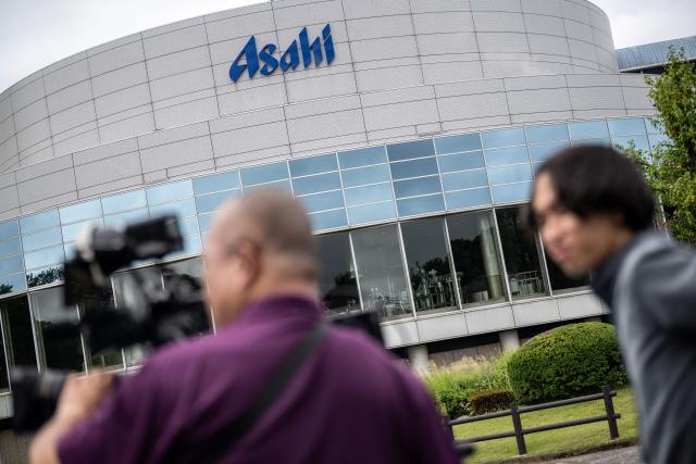(FILES) Members of the media record footage outside the Asahi Group Holdings' Ibaraki Brewery, which produces around 5.9 million cans of beer daily, during a media tour of the facility in Moriya city, Ibaraki Prefecture on September 7, 2026. Japanese authorities raided four major beer manufacturers October 7, 2026 over suspicions they colluded to hike beverage prices in a violation of anti-monopoly laws, a source familiar with the matter and the firms said. (Photo by Philip FONG / AFP)