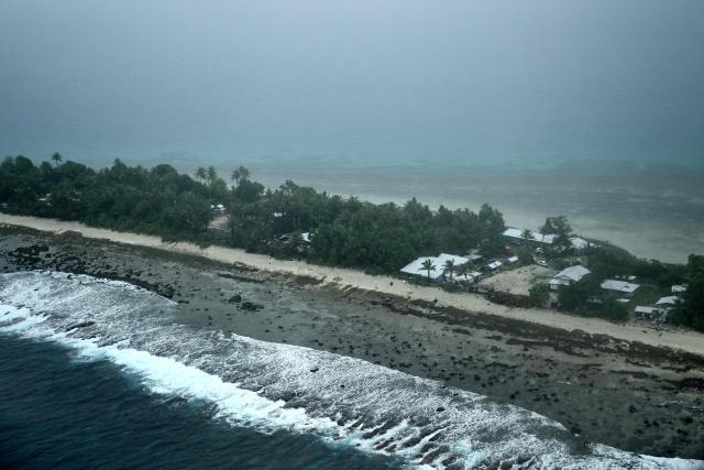 This picture taken on October 6, 2026 shows an aerial view of an island of Tuvalu on a cloudy day. The low-lying Pacific island nation is widely regarded as one of the countries most vulnerable to climate change and rising sea levels, which threaten its land, infrastructure and freshwater resources. (Photo by Saeed KHAN / AFP)
