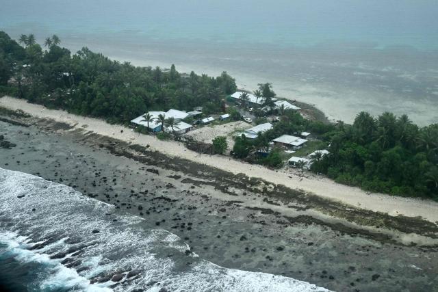 This picture taken on October 6, 2026 shows an aerial view of property on Tuvalu on a cloudy day. The low-lying Pacific island nation is widely regarded as one of the countries most vulnerable to climate change and rising sea levels, which threaten its land, infrastructure and freshwater resources. (Photo by Saeed KHAN / AFP)