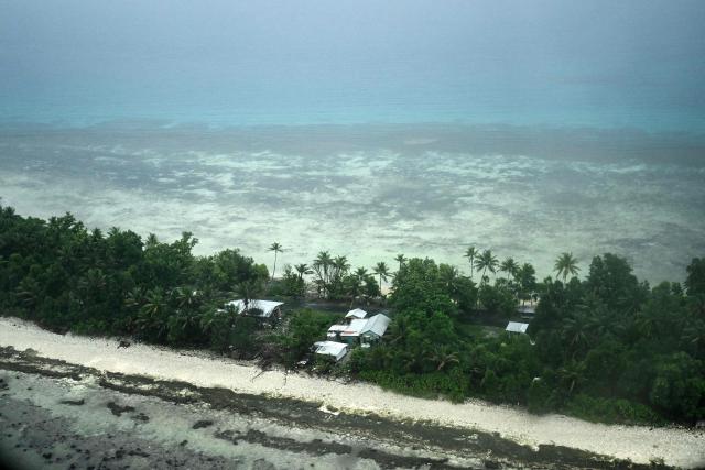 This picture taken on October 6, 2026 shows an aerial view of property on Tuvalu on a cloudy day. The low-lying Pacific island nation is widely regarded as one of the countries most vulnerable to climate change and rising sea levels, which threaten its land, infrastructure and freshwater resources. (Photo by Saeed KHAN / AFP)