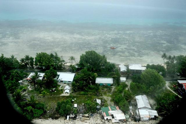 This picture taken on October 6, 2026 shows an aerial view of property on Tuvalu on a cloudy day. The low-lying Pacific island nation is widely regarded as one of the countries most vulnerable to climate change and rising sea levels, which threaten its land, infrastructure and freshwater resources. (Photo by Saeed KHAN / AFP)
