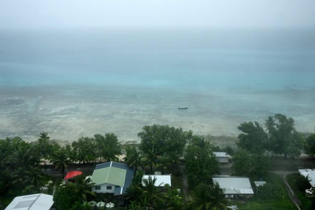This picture taken on October 6, 2026 shows an aerial view of property on Tuvalu on a cloudy day. The low-lying Pacific island nation is widely regarded as one of the countries most vulnerable to climate change and rising sea levels, which threaten its land, infrastructure and freshwater resources. (Photo by Saeed KHAN / AFP)