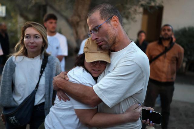 Israelis embrace each other while attending a tribute ceremony at the Kibbutz Kfar Aza, in southern Israel on October 7, 2026. Israel marks the third anniversary of Hamas's October 7, 2023 attack, just weeks before an election in which the deadliest day in the country's history will be front and centre. At 06:29 am (0329 GMT), the exact time the Hamas attack began three years ago, a tribute was held at Kibbutz Kfar Aza near the Gaza border, where militants killed 64 residents and abducted 18 people during their attack. (Photo by Ilia YEFIMOVICH / AFP)