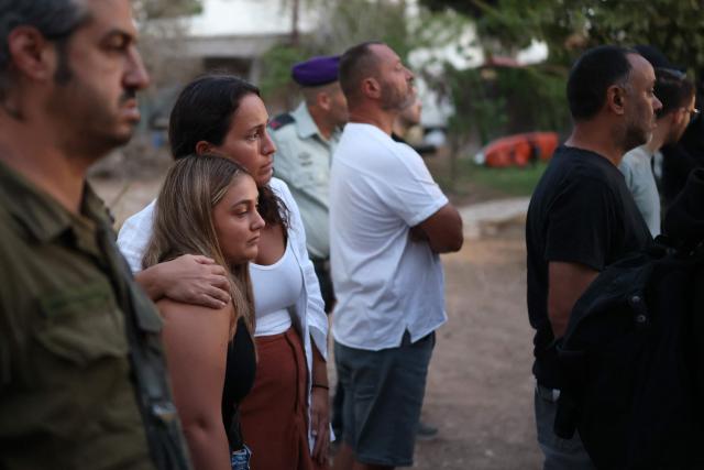 Israelis attend a tribute ceremony at the Kibbutz Kfar Aza, in southern Israel on October 7, 2026. Israel marks the third anniversary of Hamas's October 7, 2023 attack, just weeks before an election in which the deadliest day in the country's history will be front and centre. At 06:29 am (0329 GMT), the exact time the Hamas attack began three years ago, a tribute was held at Kibbutz Kfar Aza near the Gaza border, where militants killed 64 residents and abducted 18 people during their attack. (Photo by Ilia YEFIMOVICH / AFP)