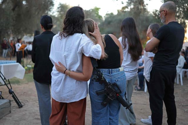 Israelis embrace each other while attending a tribute ceremony at the Kibbutz Kfar Aza, in southern Israel on October 7, 2026. Israel marks the third anniversary of Hamas's October 7, 2023 attack, just weeks before an election in which the deadliest day in the country's history will be front and centre. At 06:29 am (0329 GMT), the exact time the Hamas attack began three years ago, a tribute was held at Kibbutz Kfar Aza near the Gaza border, where militants killed 64 residents and abducted 18 people during their attack. (Photo by Ilia YEFIMOVICH / AFP)