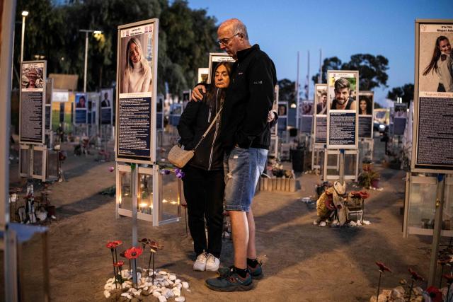 Mourners gather at the site of the Nova music festival in Re'im, southern Israel on October 7, 2026, to mark the third anniversary of Hamas's October 7, 2023 attack. Mourners observed a moment of silence on October 7 at sites in southern Israel attacked by Hamas three years earlier, the country's deadliest ever attack which triggered a massive Israeli offensive in Gaza. At the site of the Nova music festival, which Hamas militants infiltrated on October 7, 2023 through cars and paragliders, family members bowed their heads at 6:29 am (0329 GMT), surrounded by portraits of victims with flowers placed underneath. (Photo by JOHN WESSELS / AFP)