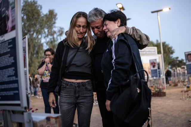 Mourners gather at the site of the Nova music festival in Re'im, southern Israel on October 7, 2026, to mark the third anniversary of Hamas's October 7, 2023 attack. Mourners observed a moment of silence on October 7 at sites in southern Israel attacked by Hamas three years earlier, the country's deadliest ever attack which triggered a massive Israeli offensive in Gaza. At the site of the Nova music festival, which Hamas militants infiltrated on October 7, 2023 through cars and paragliders, family members bowed their heads at 6:29 am (0329 GMT), surrounded by portraits of victims with flowers placed underneath. (Photo by John Wessels / AFP)