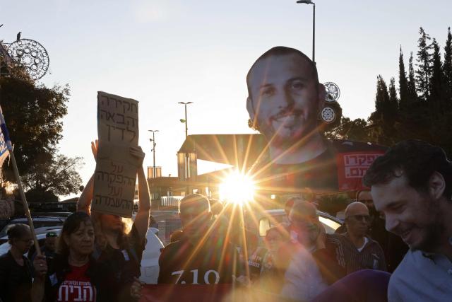 Israelis hold placards, banners and cut-outs of of victims as they gather outside the Knesset, Israel's parliament in Jerusalem on October 7, 2026, to mark the third anniversary of Hamas's October 7, 2023 attack. Israel marks the third anniversary of Hamas's October 7, 2023 attack, just weeks before an election in which the deadliest day in the country's history will be front and centre. (Photo by AHMAD GHARABLI / AFP)