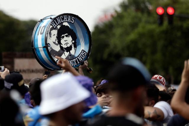 (FILES) A fan of Argentina carries a drum depicting football legend Diego Maradona outside the Monumental stadium before the friendly football match between Argentina and Panama in Buenos Aires, on March 23, 2023. The trial over Diego Maradona's death enters its final stage in early October 2026 after almost six months of hearings, with the question still unresolved as to whether the football icon's death in late 2020 was unforeseeable or the result of medical negligence during his home care. (Photo by Emiliano Lasalvia / AFP)