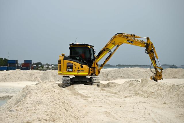 This photo taken on October 6, 2026 shows construction work in progress at a land reclamation site in Funafuti. Tuvalu is expanding adaptation measures, including land reclamation and coastal protection works, as rising sea levels linked to climate change threaten the future of the low-lying Pacific island nation. (Photo by Saeed KHAN / POOL / AFP)