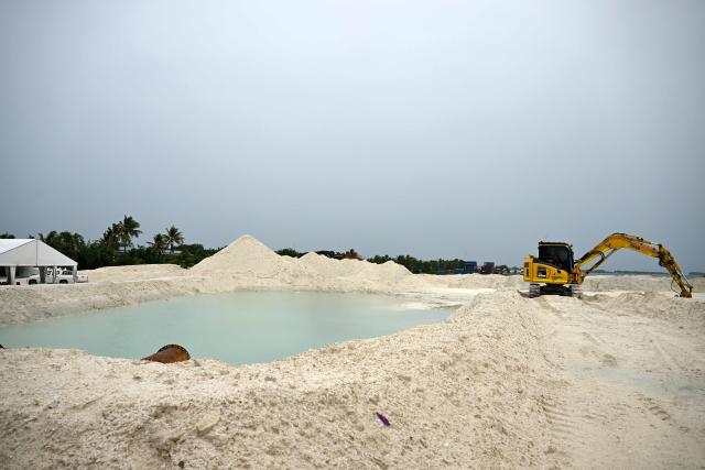 This photo taken on October 6, 2026 shows construction work in progress at a land reclamation site in Funafuti. Tuvalu is expanding adaptation measures, including land reclamation and coastal protection works, as rising sea levels linked to climate change threaten the future of the low-lying Pacific island nation. (Photo by Saeed KHAN / POOL / AFP)