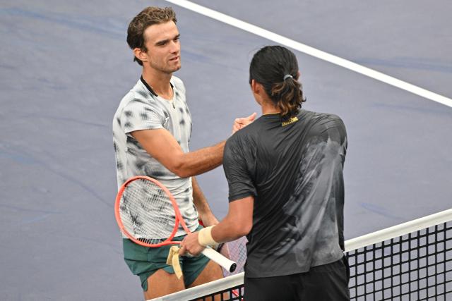 Czech Republic's Tomas Machac (L) shakes hands with China's Zhizhen Zhang after winning their men's singles match at the Shanghai Masters tennis tournament in Shanghai on October 7, 2026. (Photo by Hector RETAMAL / AFP)