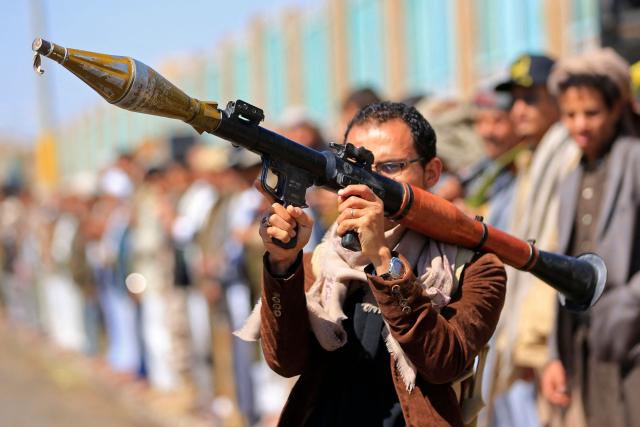A fighter loyal to the Houthi authorities, brandishes his weapon during a rally to recruit more fighters, in Sanaa on October 7, 2026. The Houthis claimed a flurry of attacks on Saudi targets on October 7 including firing a ballistic missile at Riyadh airport, as the group battles for territory in Yemen against government forces supported by the kingdom. (Photo by Mohammed HUWAIS / AFP)