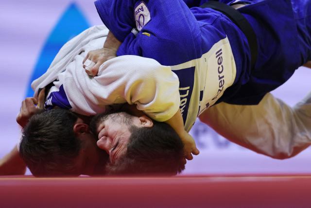 Serbia's Mihajlo Simin (white) competes against Azerbijan's Omar Rajabli in the men's under 81 kg quarter-final at the World Judo Championships in Baku on October 7, 2026. (Photo by Anne-Christine POUJOULAT / AFP)