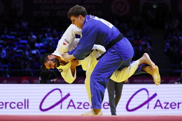 Georgia's Tato Grigalashvili (white) competes against Serbia's Mihajlo Simin in the men's under 81 kg semi-final at the World Judo Championships in Baku on October 7, 2026. (Photo by Anne-Christine POUJOULAT / AFP)