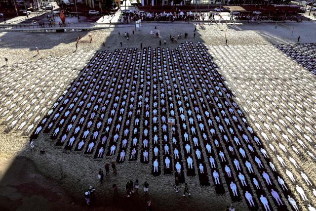 An aerial view shows people standing on the beach next to a commemorative installation marking the third anniversary of Hamas's October 7 attack on Israel, in Tel Aviv on October 7, 2026. Israel marked the third anniversary of Hamas's October 7 attack with silent tributes, new strikes on Gaza and intense political debate, weeks before elections in which the country's deadliest day will be front and centre. (Photo by Jack GUEZ / AFP)
