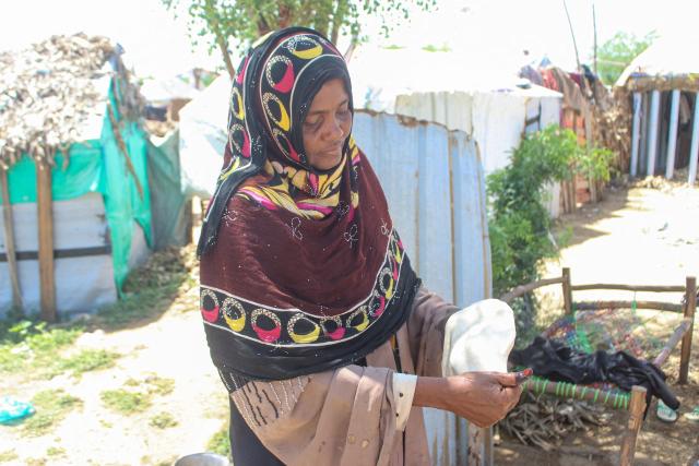 An internally displaced Yemeni woman kneads a dough at a makeshift camp for the internally displaced who fled their homes due to renewed clashes between Yemen's Saudi-backed government forces and the Houthi authorities in the northern Hajjah governorate on October 7, 2026. More than 200,000 people have been displaced in Yemen since fighting resumed between the Houthis and the Saudi-backed internationally recognised government, a UN agency said on October 7. (Photo by Essa AHMED / AFP)