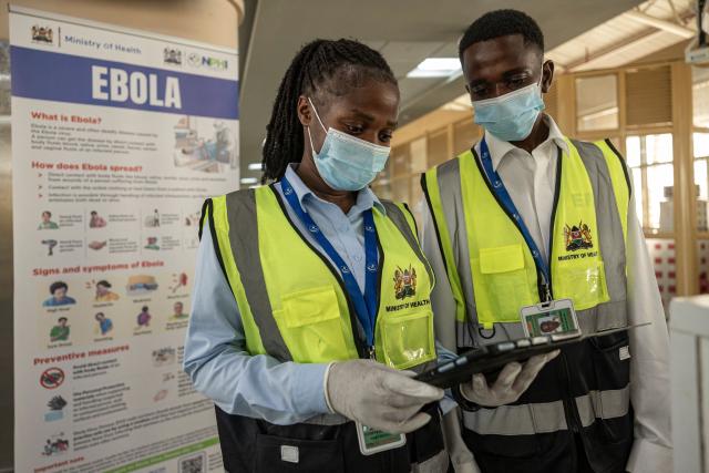 Port health officials from Kenya's Ministry of Health monitor data as they wait for passengers at the arrival screening point at the Jomo Kenyatta International Airport in Nairobi on October 7, 2026. Kenya has reported its first-ever Ebola death, the health minister announced on October 6, 2026, after a Kenyan man who had been living in the Democratic Republic of Congo died after returning to the country. (Photo by SIMON MAINA / AFP)
