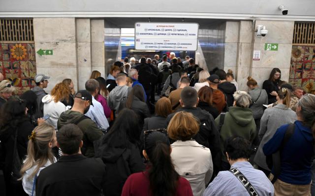 Passengers wait in a metro station during an air raid alert as metro trains stopped crossing the Dnipro River by the bridge to the left bank of Kyiv on October 7, 2026, amid the Russian invasion of Ukraine. (Photo by Sergei SUPINSKY / AFP)