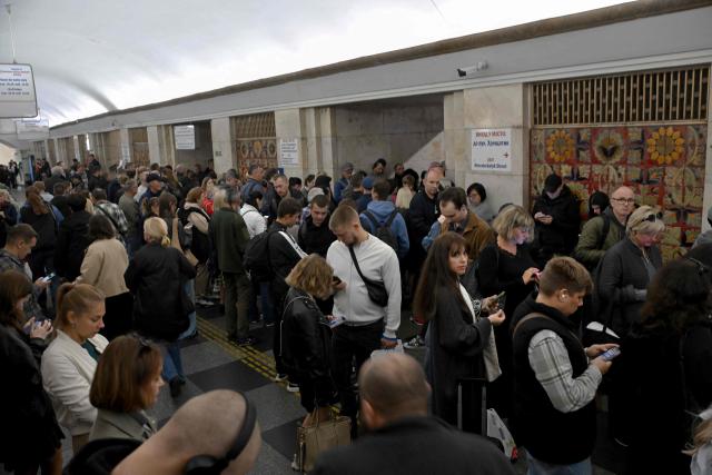 Passengers wait in a metro station during an air raid alert as metro trains stopped crossing the Dnipro River by the bridge to the left bank of Kyiv on October 7, 2026, amid the Russian invasion of Ukraine. (Photo by Sergei SUPINSKY / AFP)