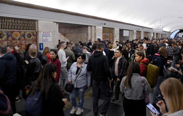 Passengers wait in a metro station during an air raid alert as metro trains stopped crossing the Dnipro River by the bridge to the left bank of Kyiv on October 7, 2026, amid the Russian invasion of Ukraine. (Photo by Sergei SUPINSKY / AFP)