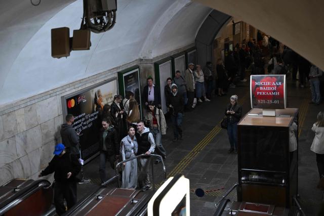 Passengers wait in a metro station during an air raid alert as metro trains stopped crossing the Dnipro River by the bridge to the left bank of Kyiv on October 7, 2026, amid the Russian invasion of Ukraine. (Photo by Sergei SUPINSKY / AFP)