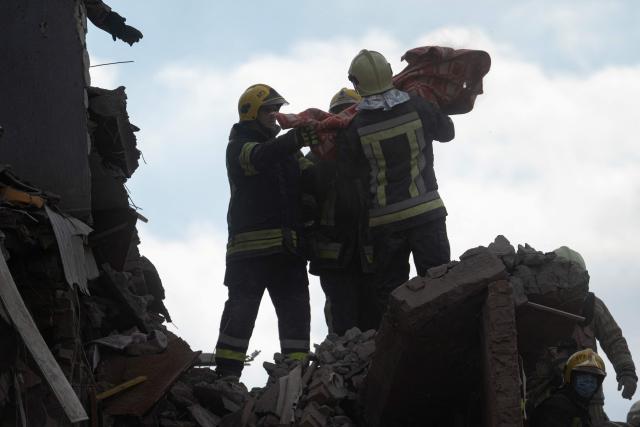 Rescuers carry the body of a child they recovered from the rubble during a search and rescue operation carried out at the site of a Russian airstrike that hit a multi-storey residential building in Pryluky on October 7, 2026, amid the Russian invasion of Ukraine. (Photo by Genya SAVILOV / AFP)